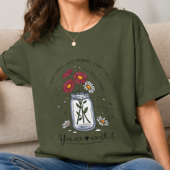 A four-panel collage showing an olive green graphic T-shirt worn by a model in different settings, plus a flat lay of the same shirt. The shirt features a mason jar design with flowers, a cross, and the text 'You are worth it'.